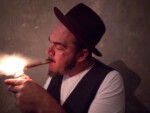 Pugsley Buzzard lighting a cigar.